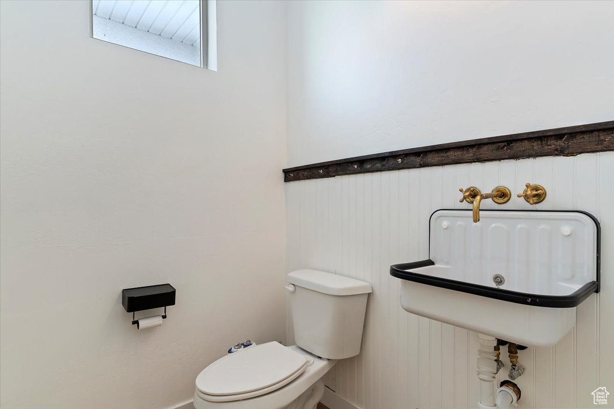 Bathroom featuring wood walls and toilet