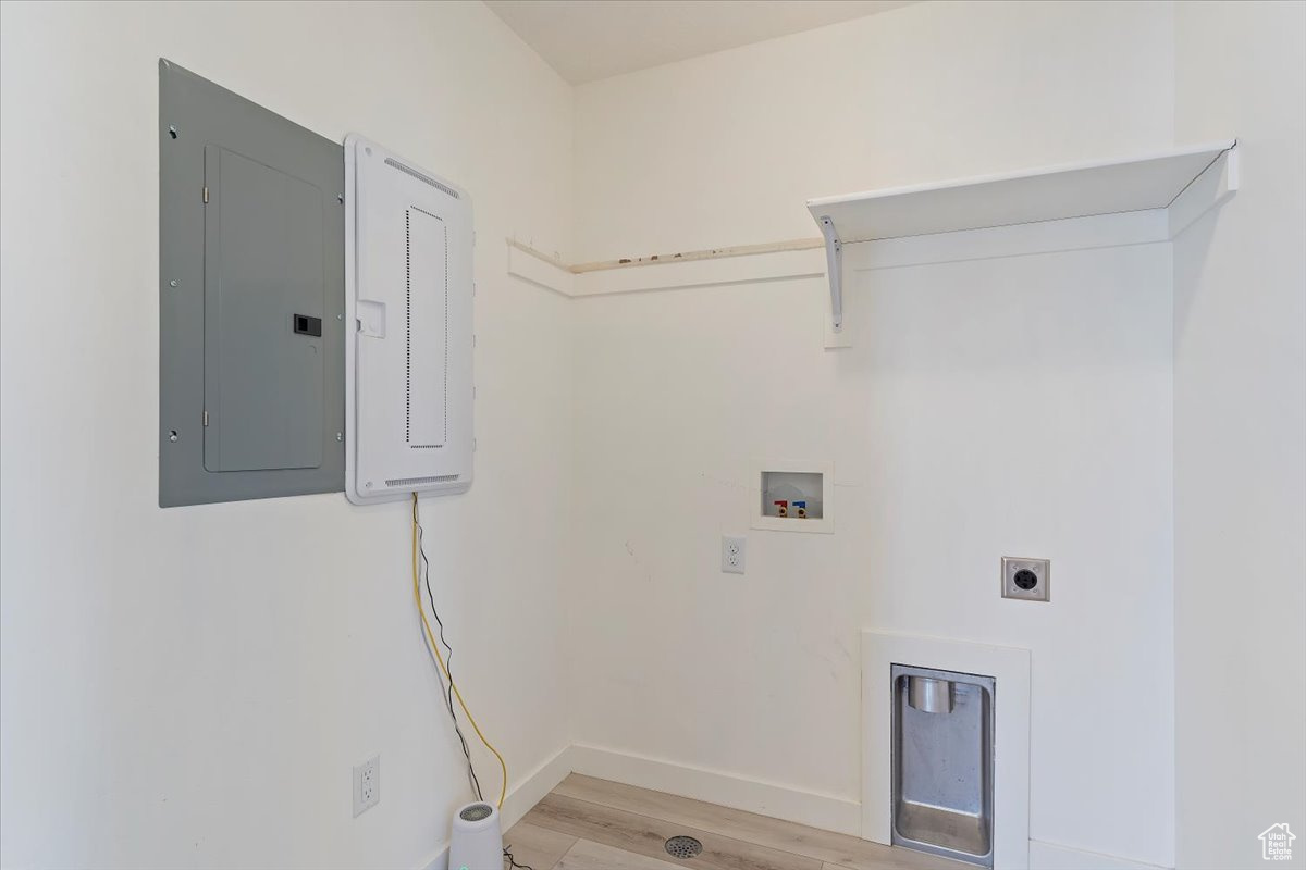 Washroom with washer hookup, electric dryer hookup, light hardwood / wood-style floors, and electric panel