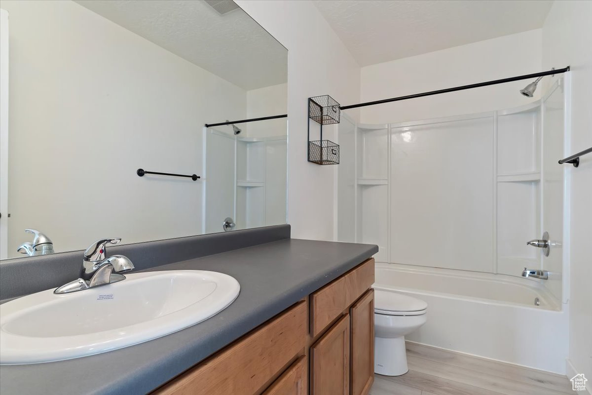 Full bathroom featuring bathtub / shower combination, wood-type flooring, vanity, and toilet