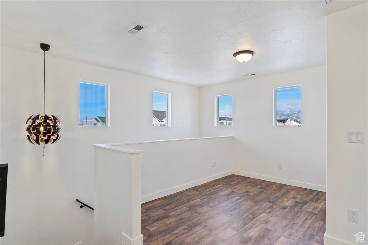 Spare room featuring a textured ceiling and dark hardwood / wood-style flooring