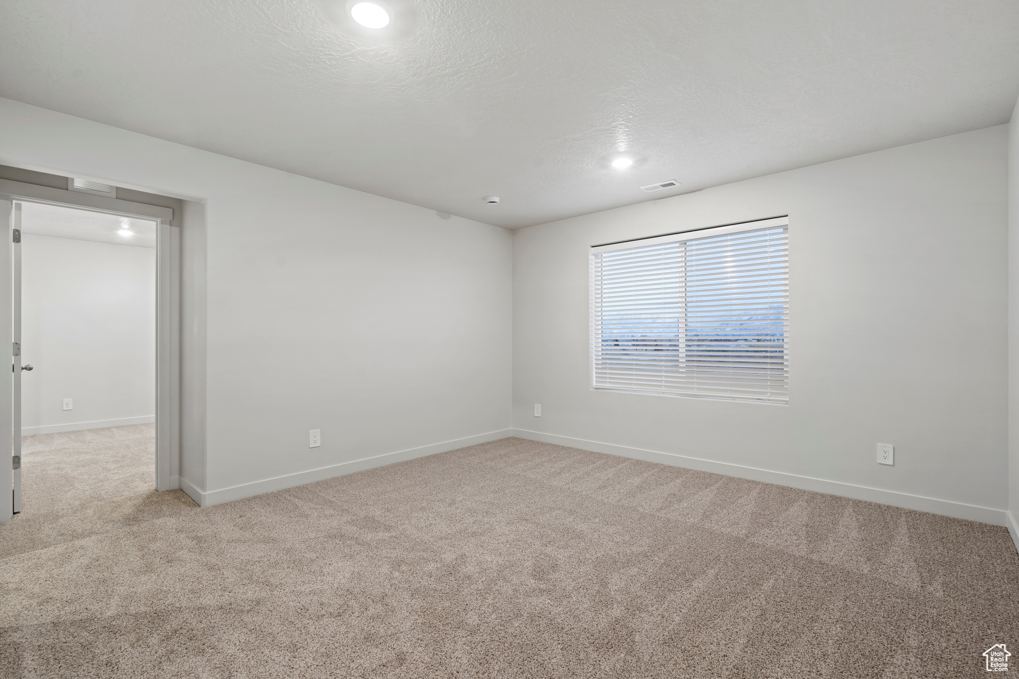 Carpeted empty room with a textured ceiling