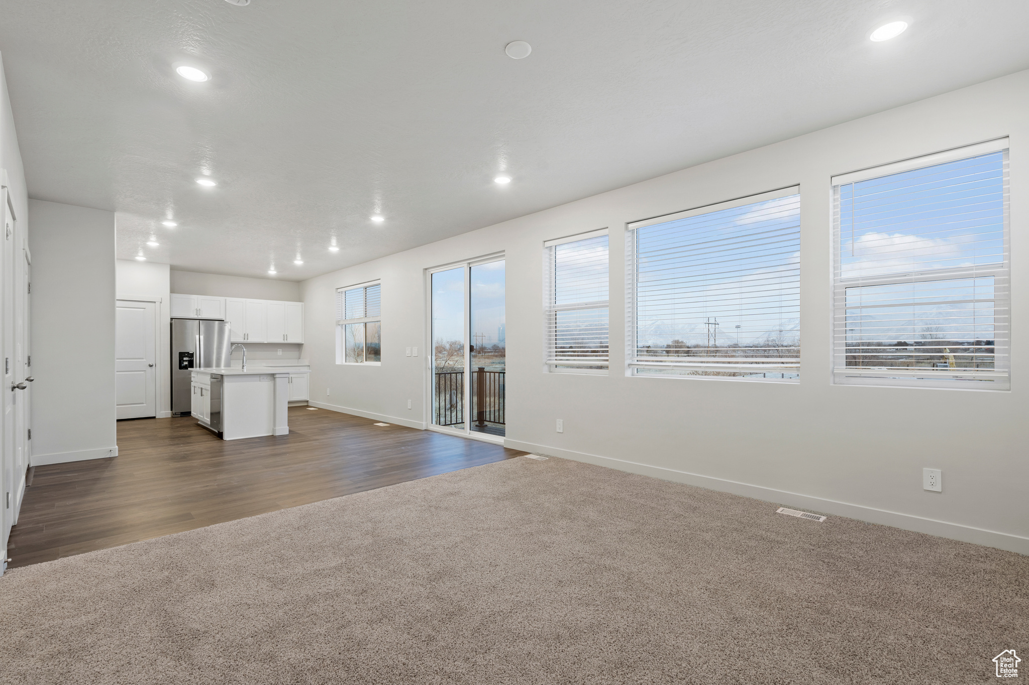 Unfurnished living room featuring plenty of natural light and carpet