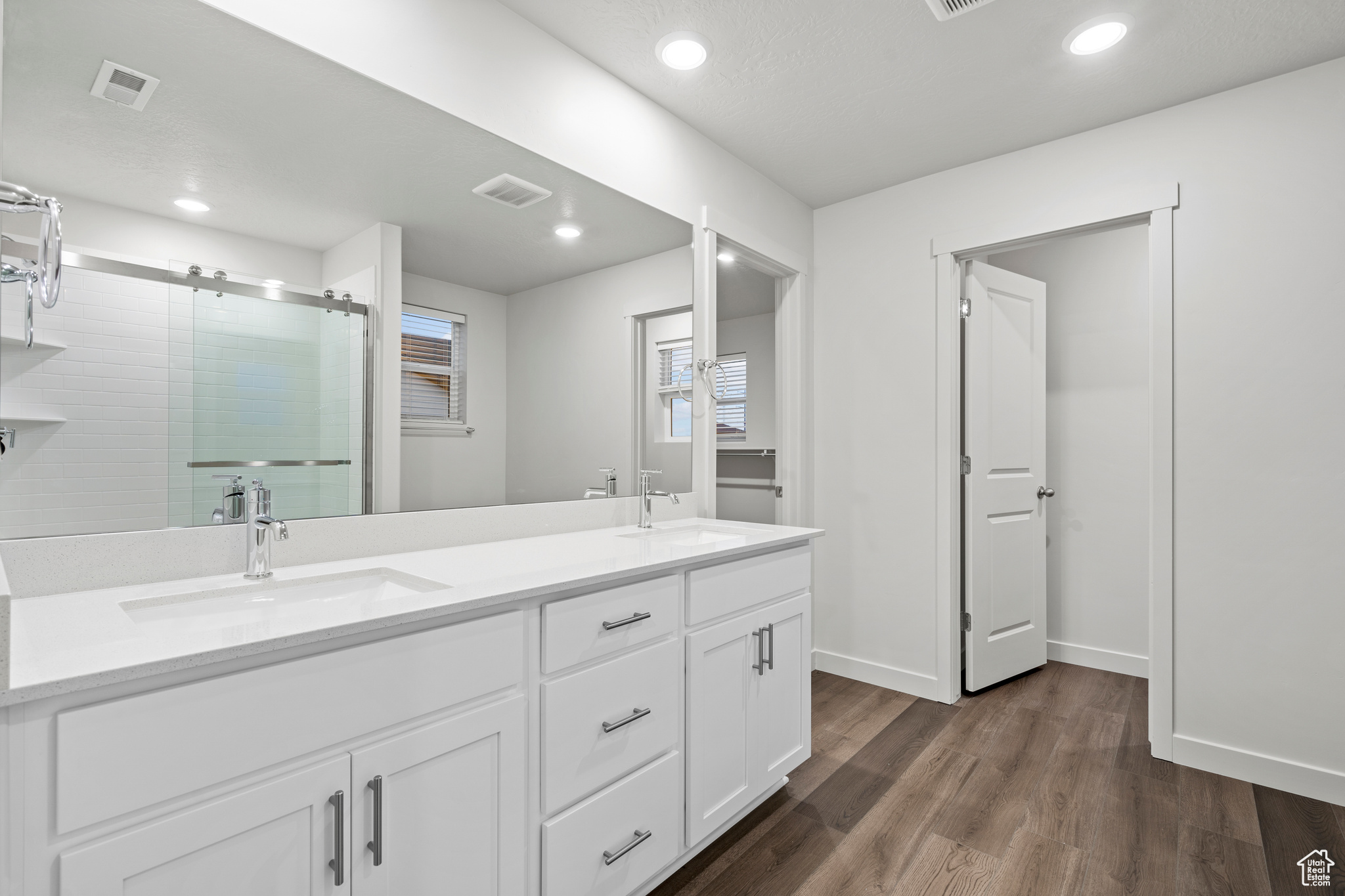 Bathroom featuring vanity, an enclosed shower, and wood-type flooring