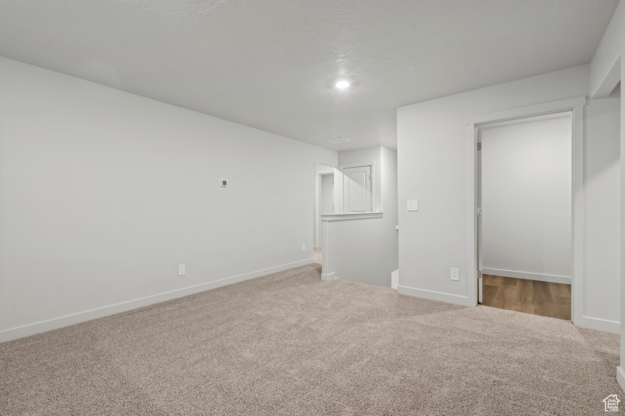 Unfurnished bedroom featuring carpet, a textured ceiling, and a closet