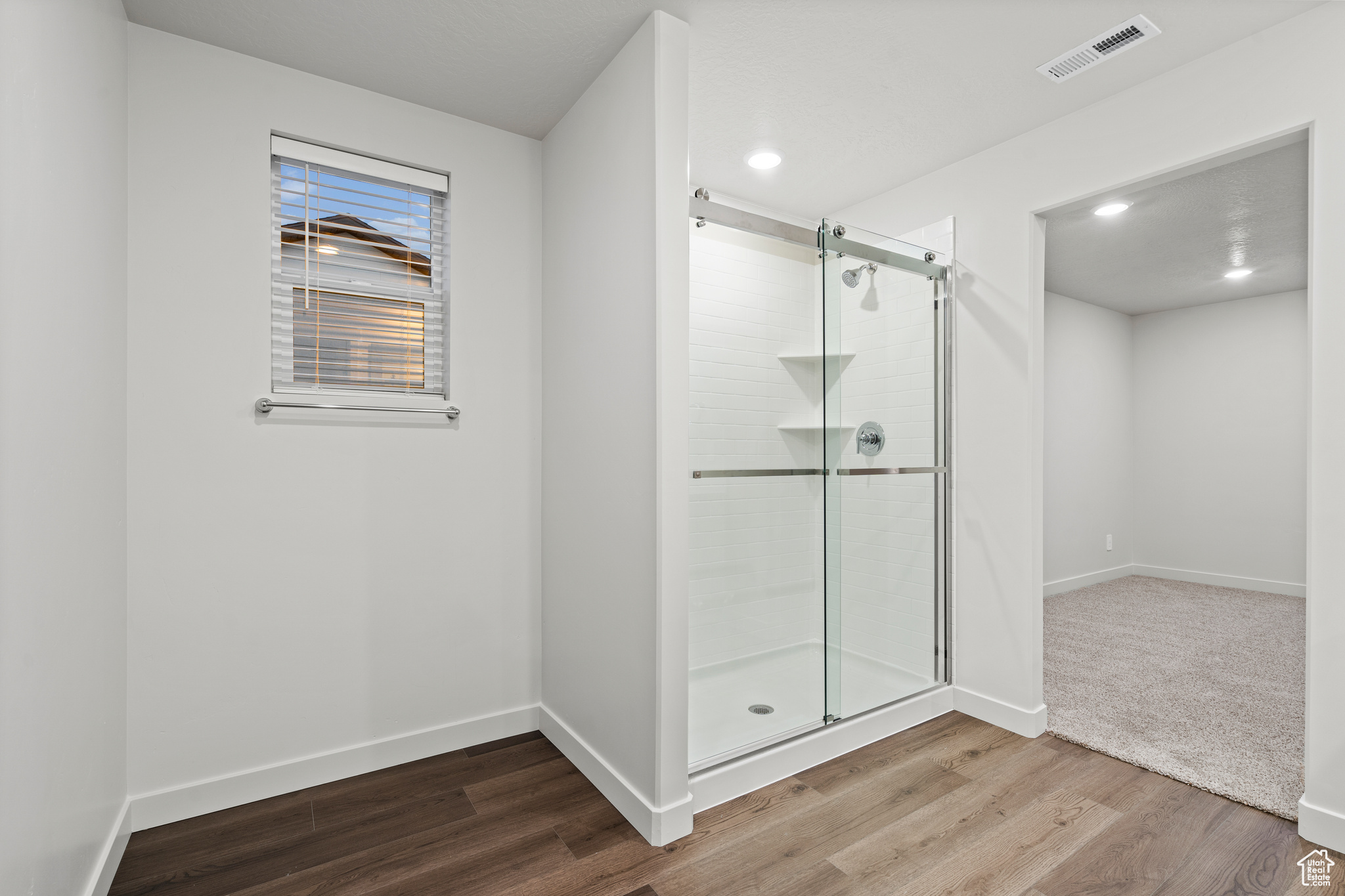 Bathroom with walk in shower and hardwood / wood-style floors