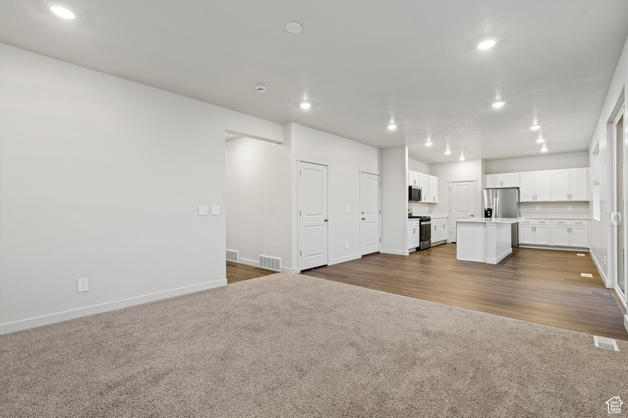 Unfurnished living room featuring dark colored carpet