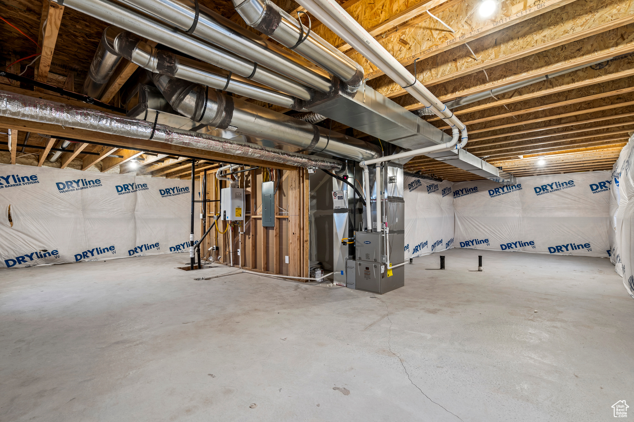 Basement featuring electric panel and heating unit