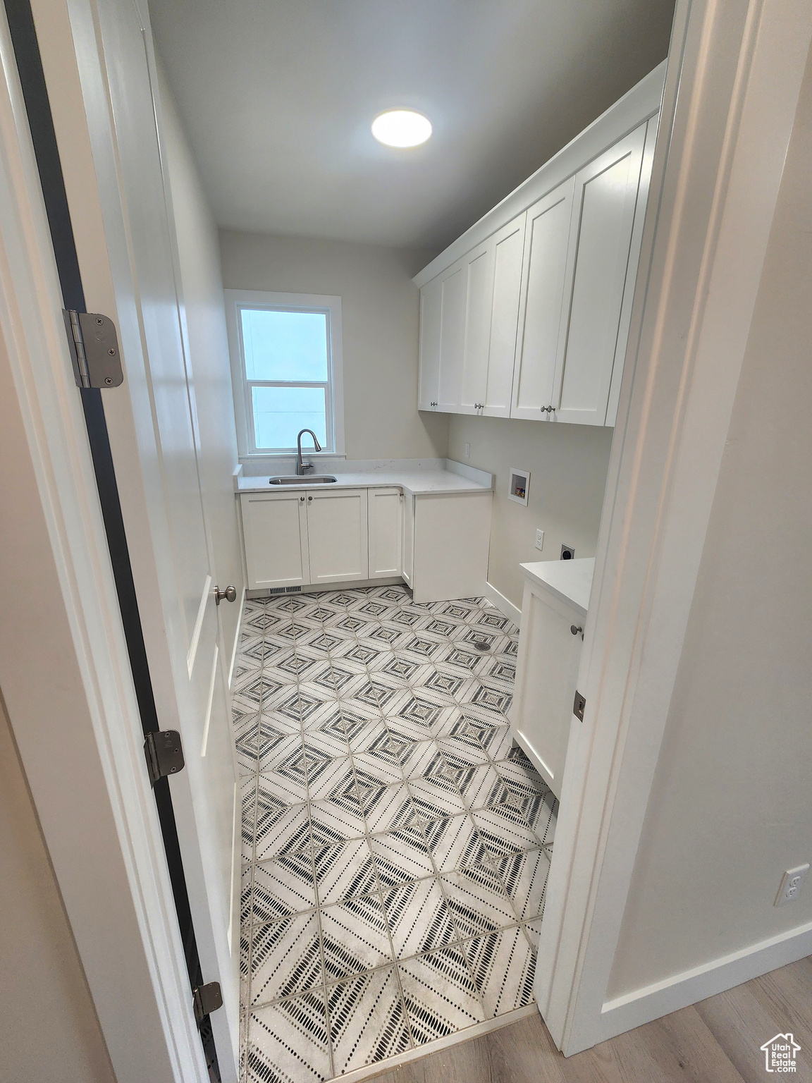 Laundry room featuring cabinets, washer hookup, light hardwood / wood-style floors, and sink