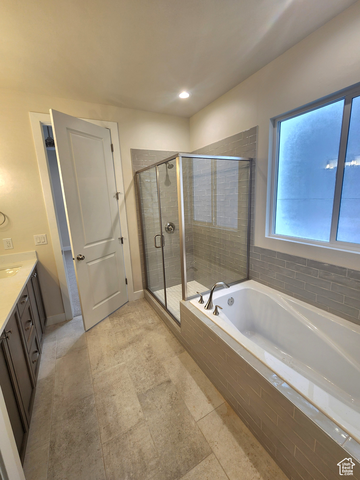 Bathroom featuring plus walk in shower and vanity