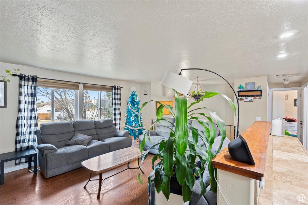 Living room with a textured ceiling and hardwood / wood-style flooring