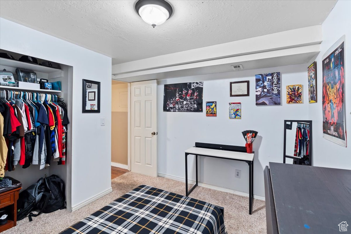 Bedroom with a textured ceiling and a closet