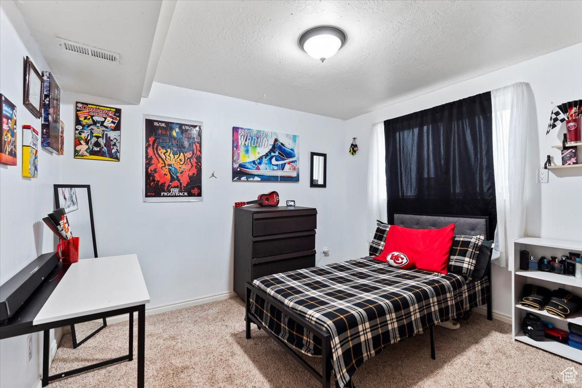 Carpeted bedroom featuring a textured ceiling