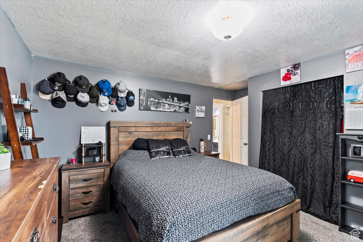 Bedroom with carpet floors and a textured ceiling