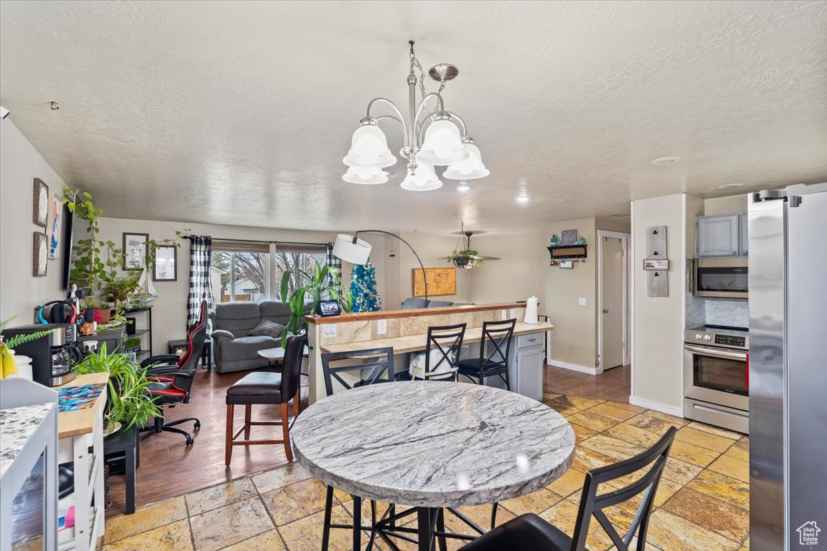 Dining area featuring a textured ceiling and an inviting chandelier