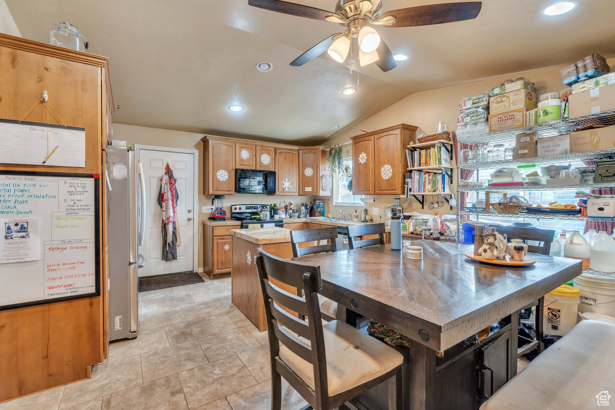 Dining space featuring light tile patterned floors, ceiling fan, and lofted ceiling