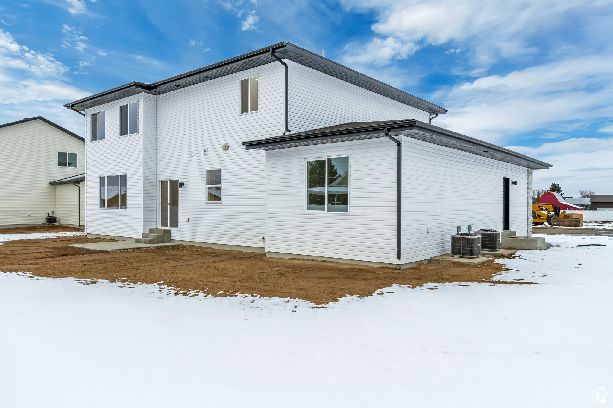 Snow covered back of property with cooling unit