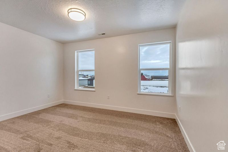 Carpeted empty room featuring a textured ceiling