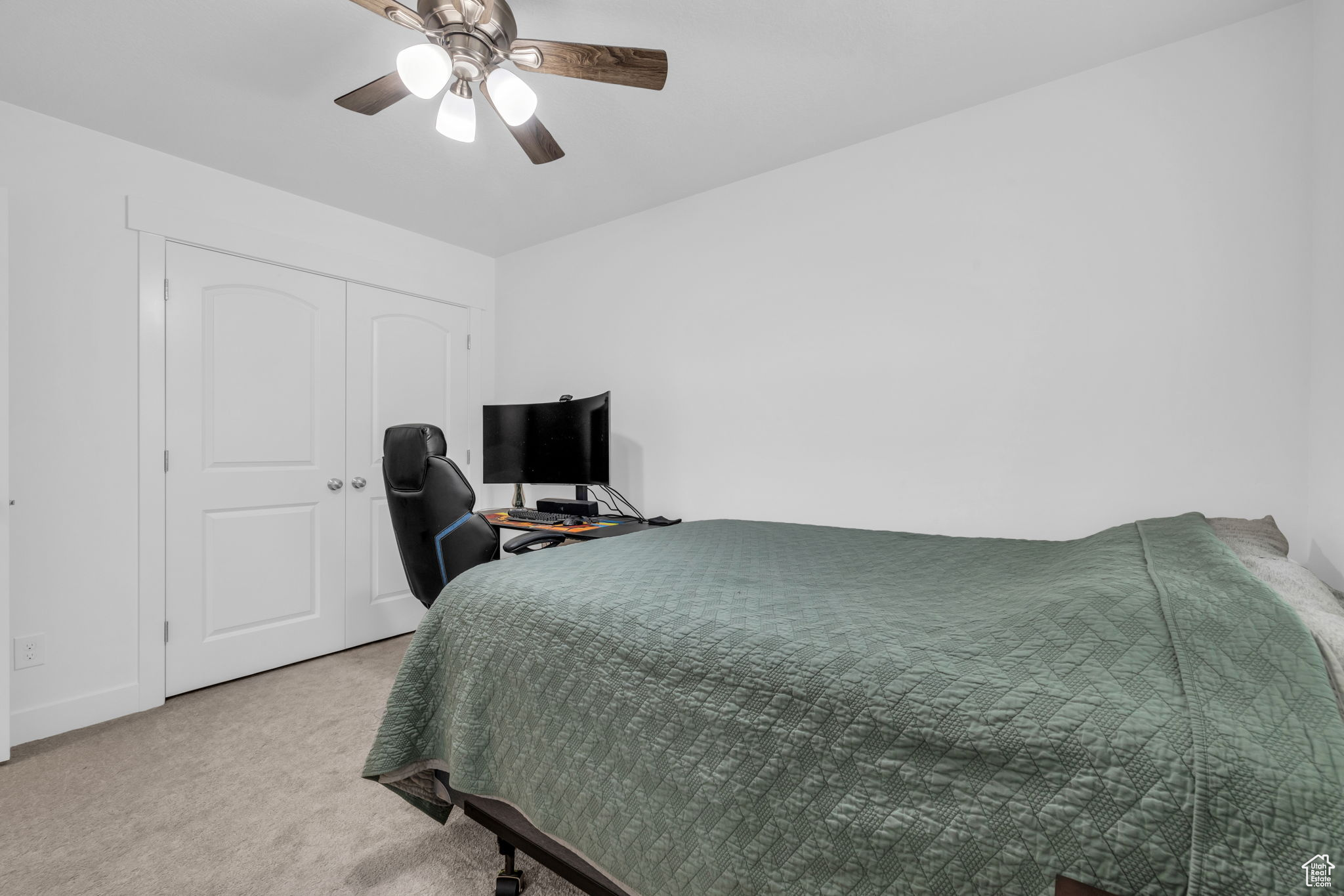 Carpeted bedroom with a closet and ceiling fan