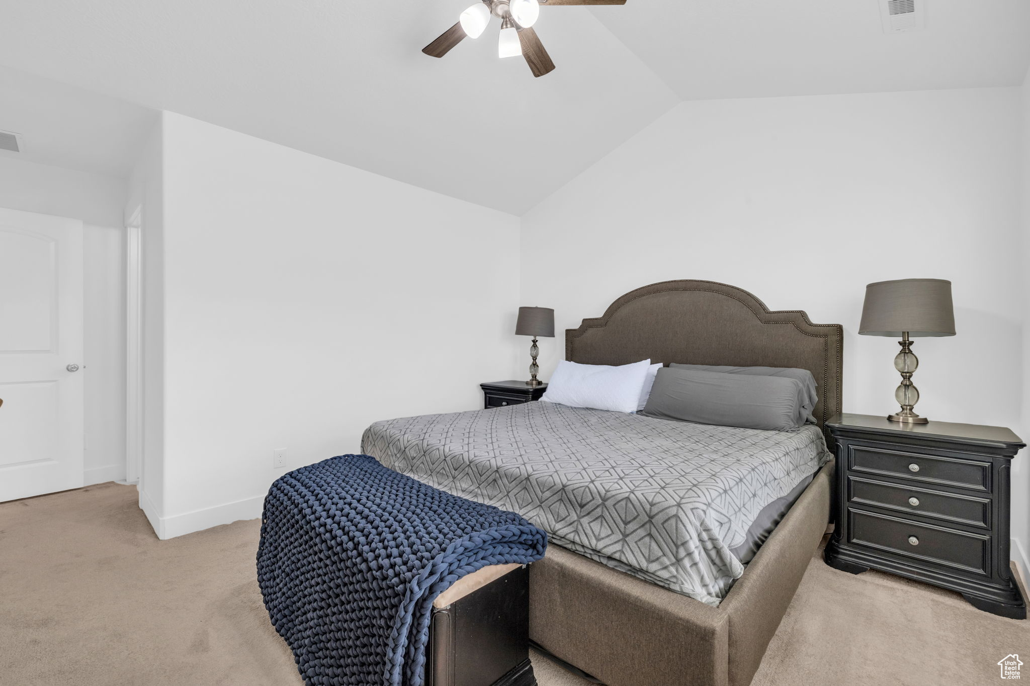 Bedroom with light colored carpet, ceiling fan, and lofted ceiling