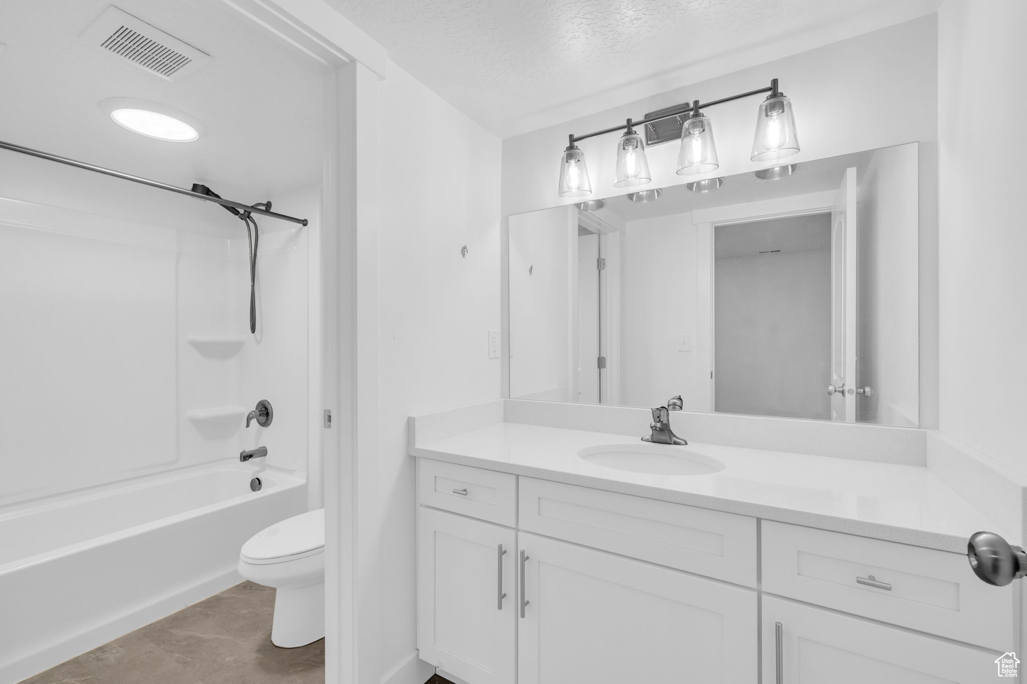 Full bathroom featuring tile patterned floors, tub / shower combination, a textured ceiling, vanity, and toilet