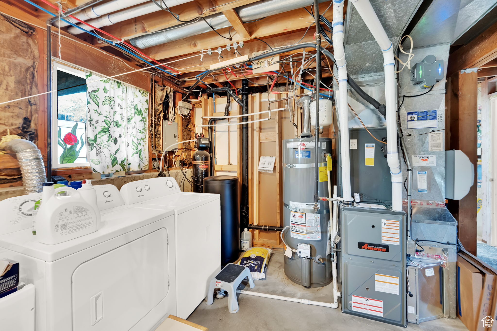 Laundry area with heating unit, water heater, and washer and clothes dryer