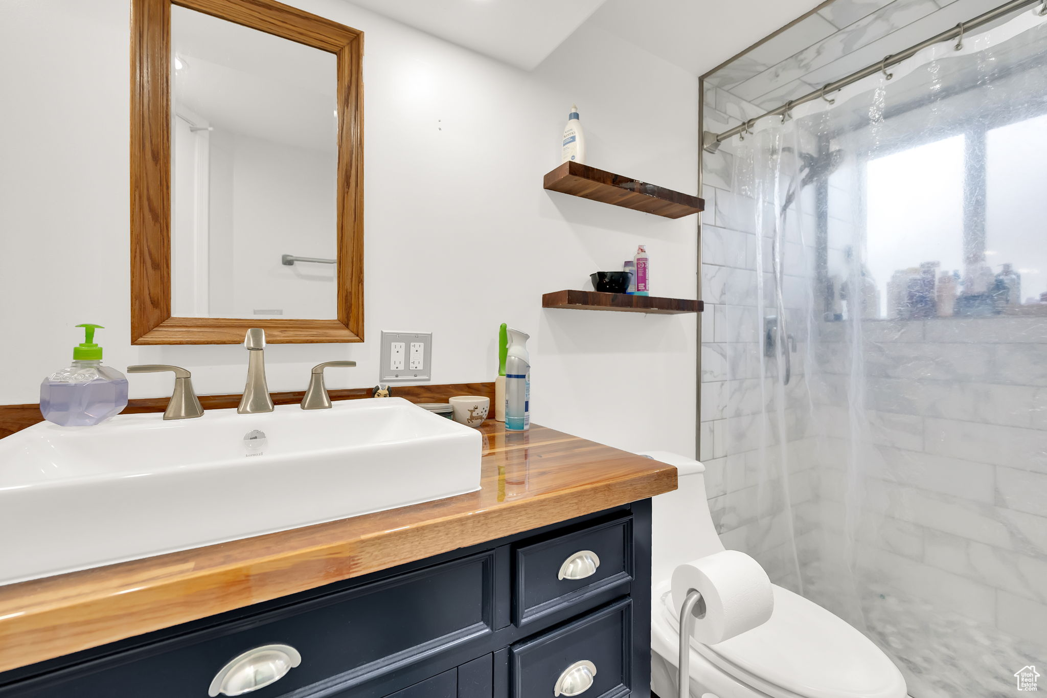 Bathroom featuring vanity, a shower with shower curtain, and toilet