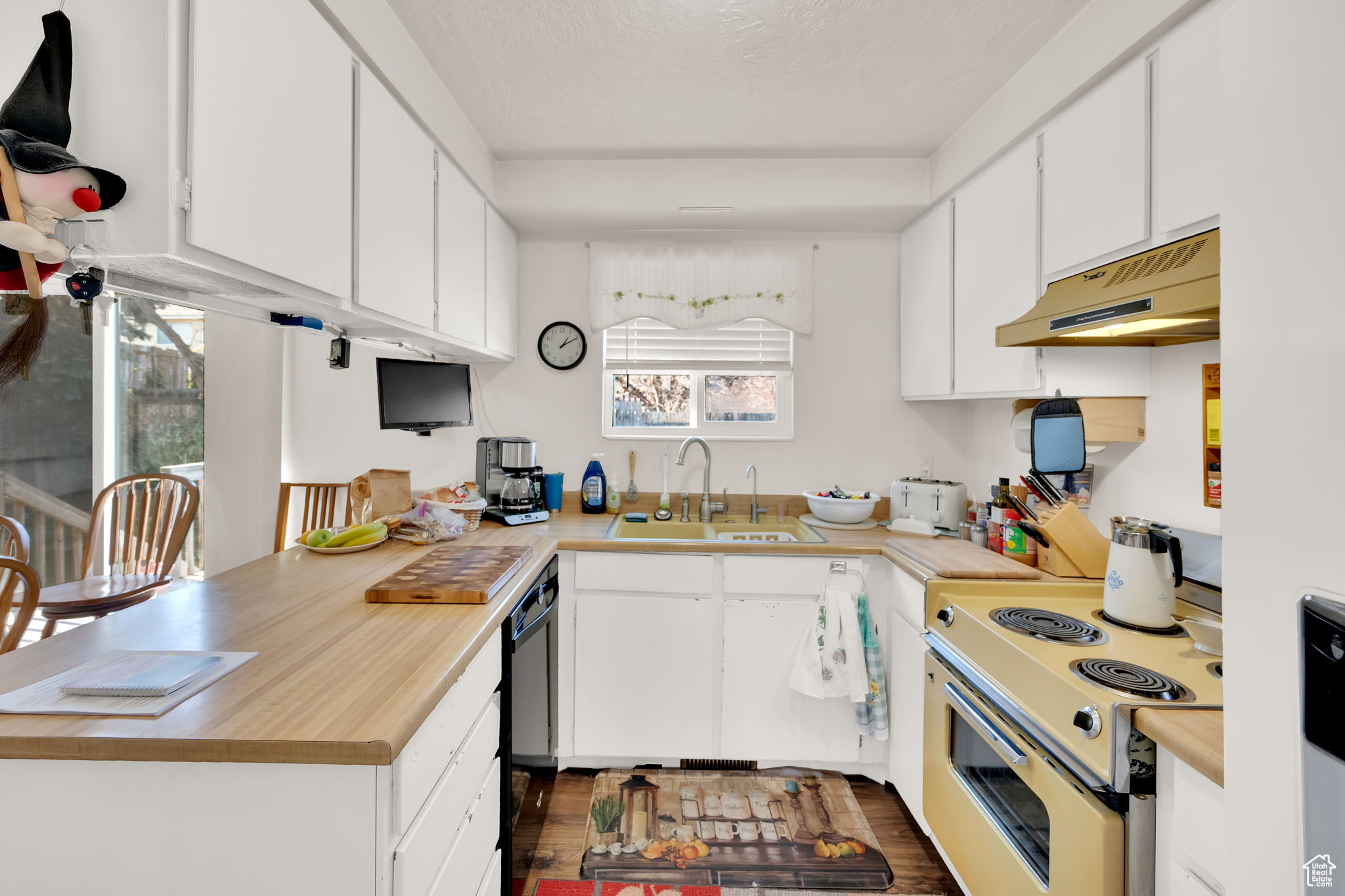 Kitchen with dark hardwood / wood-style flooring, sink, white cabinets, and white electric stove