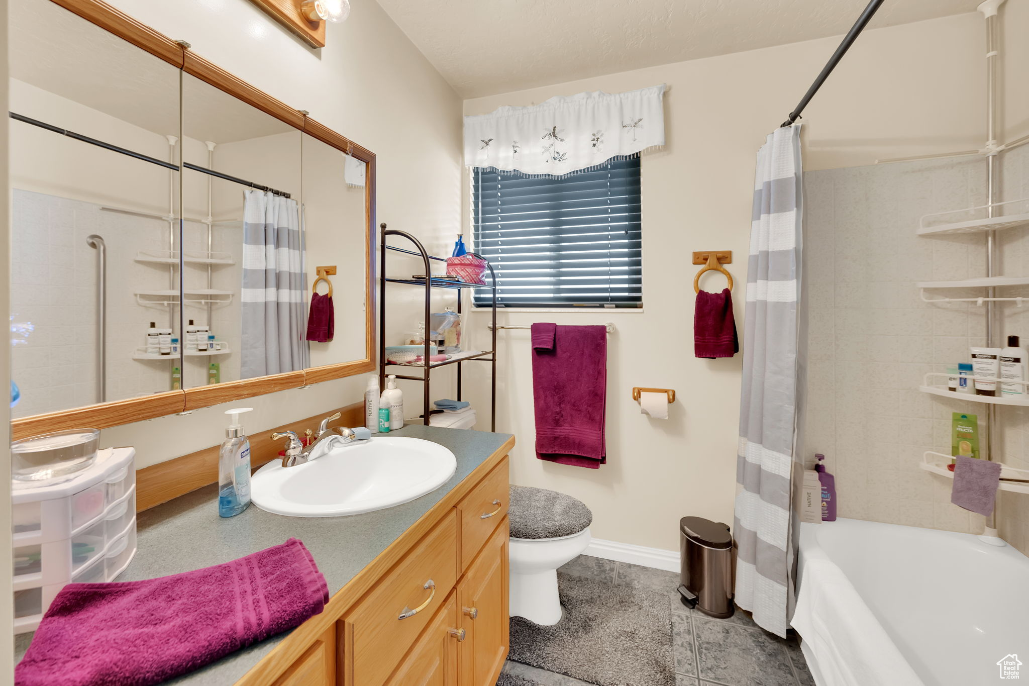 Full bathroom featuring tile patterned flooring, vanity, shower / tub combo, and toilet