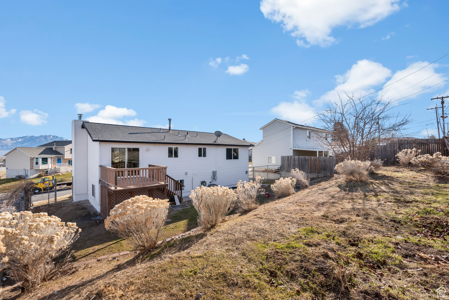 Rear view of property featuring a yard and a deck