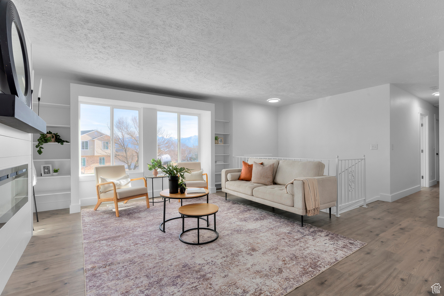 Living room with light hardwood / wood-style flooring and a textured ceiling