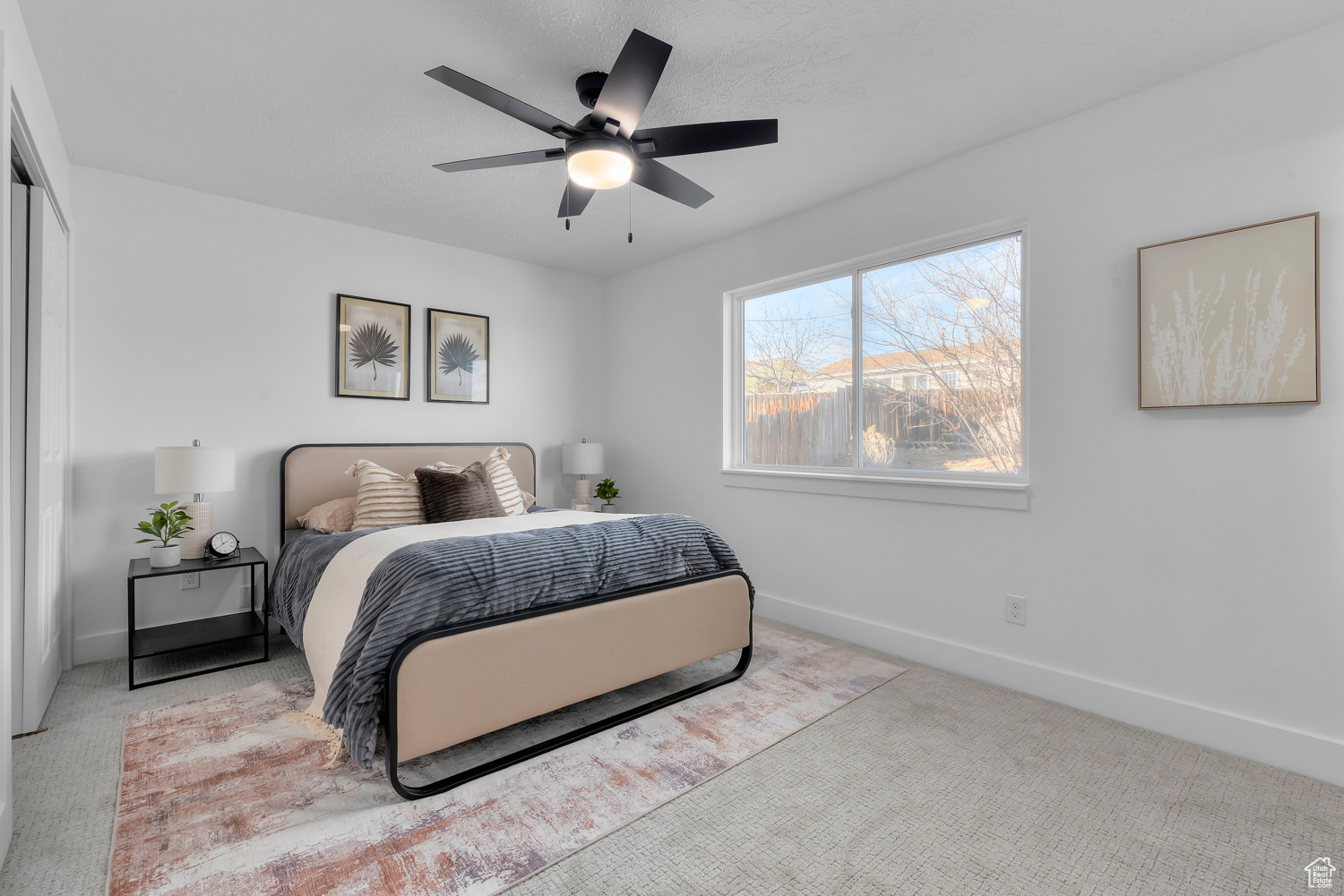 Carpeted bedroom featuring ceiling fan