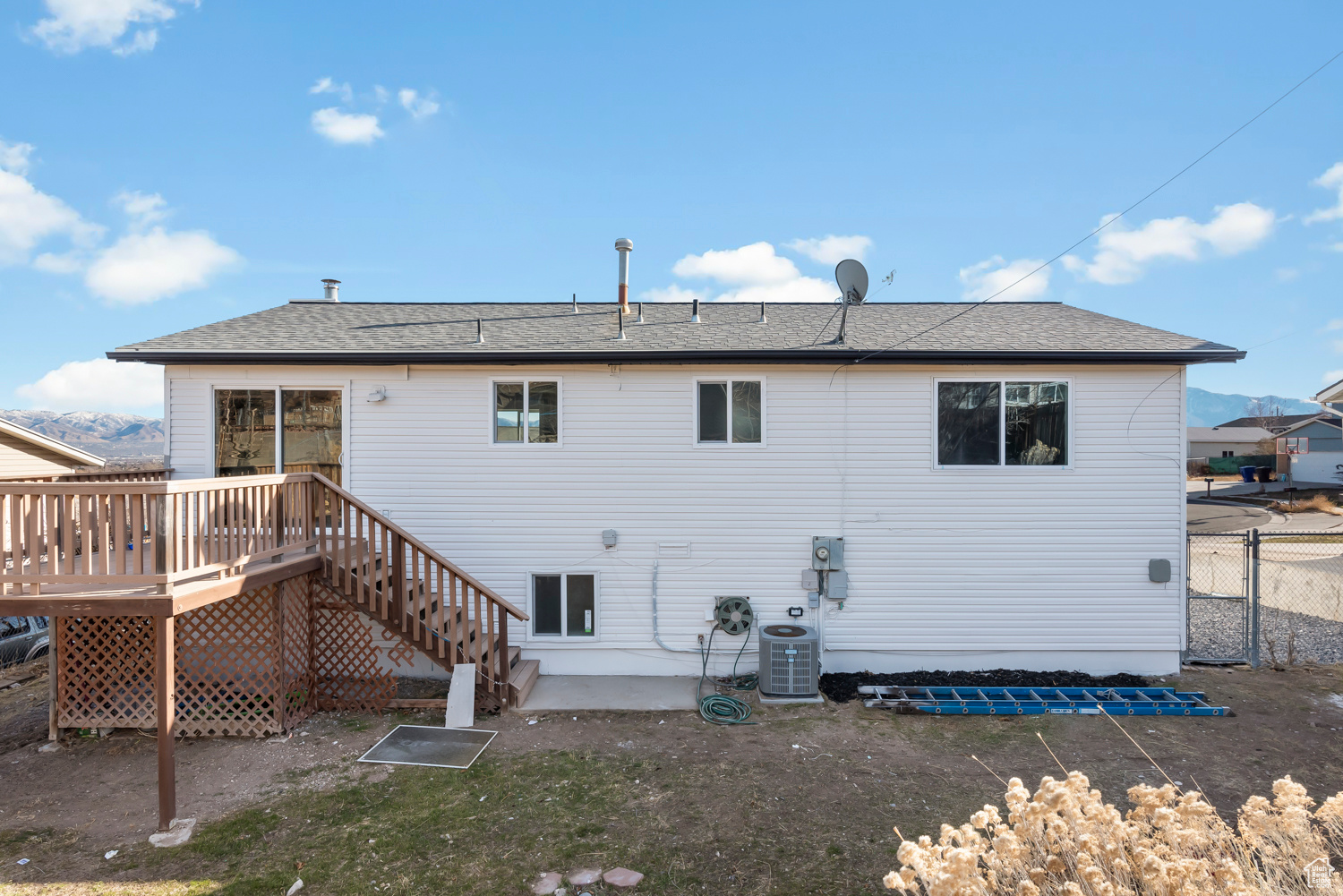 Rear view of house with a deck and cooling unit