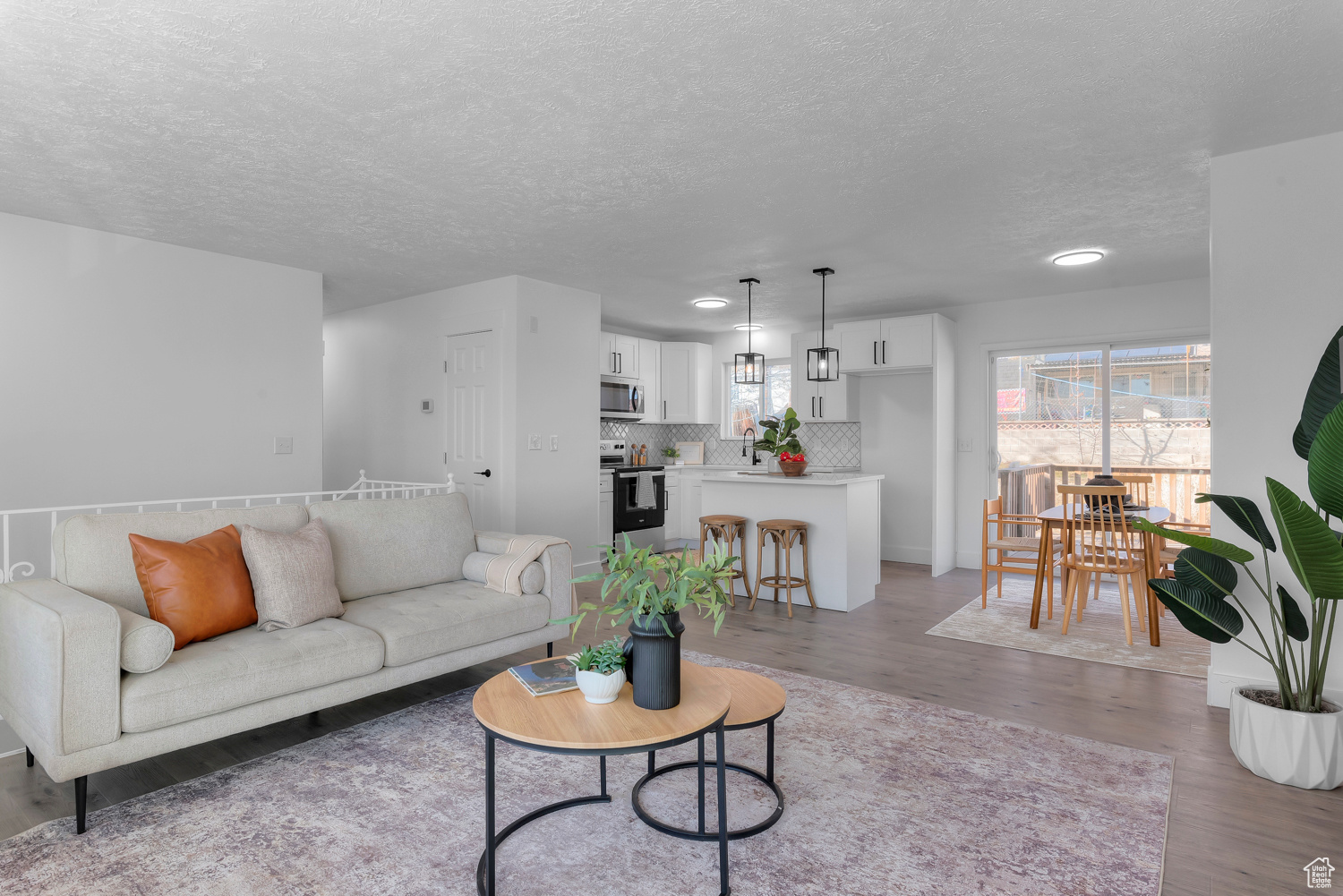 Living room featuring light hardwood / wood-style flooring, a textured ceiling, and sink