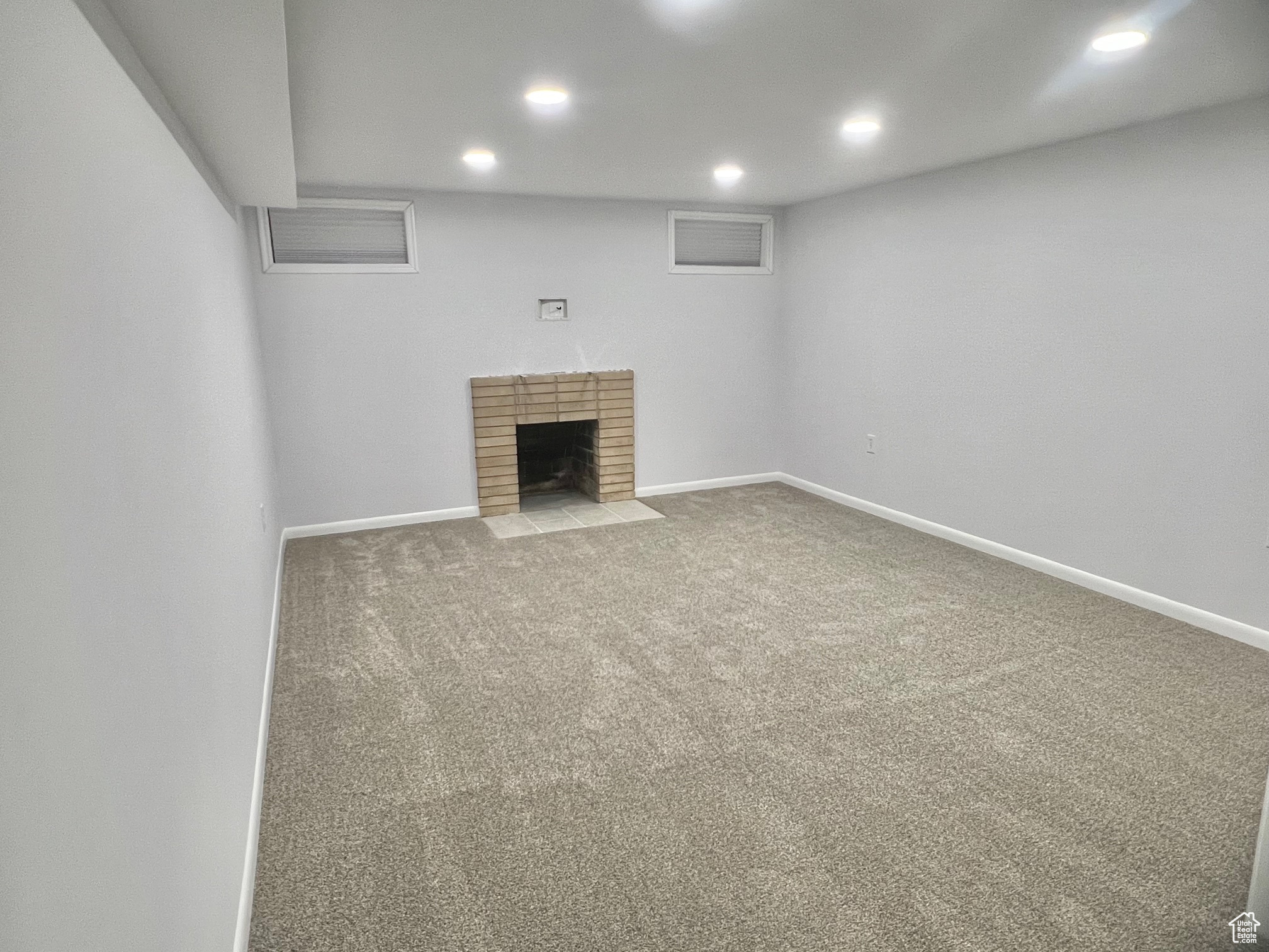 Unfurnished living room with a fireplace and carpet floors