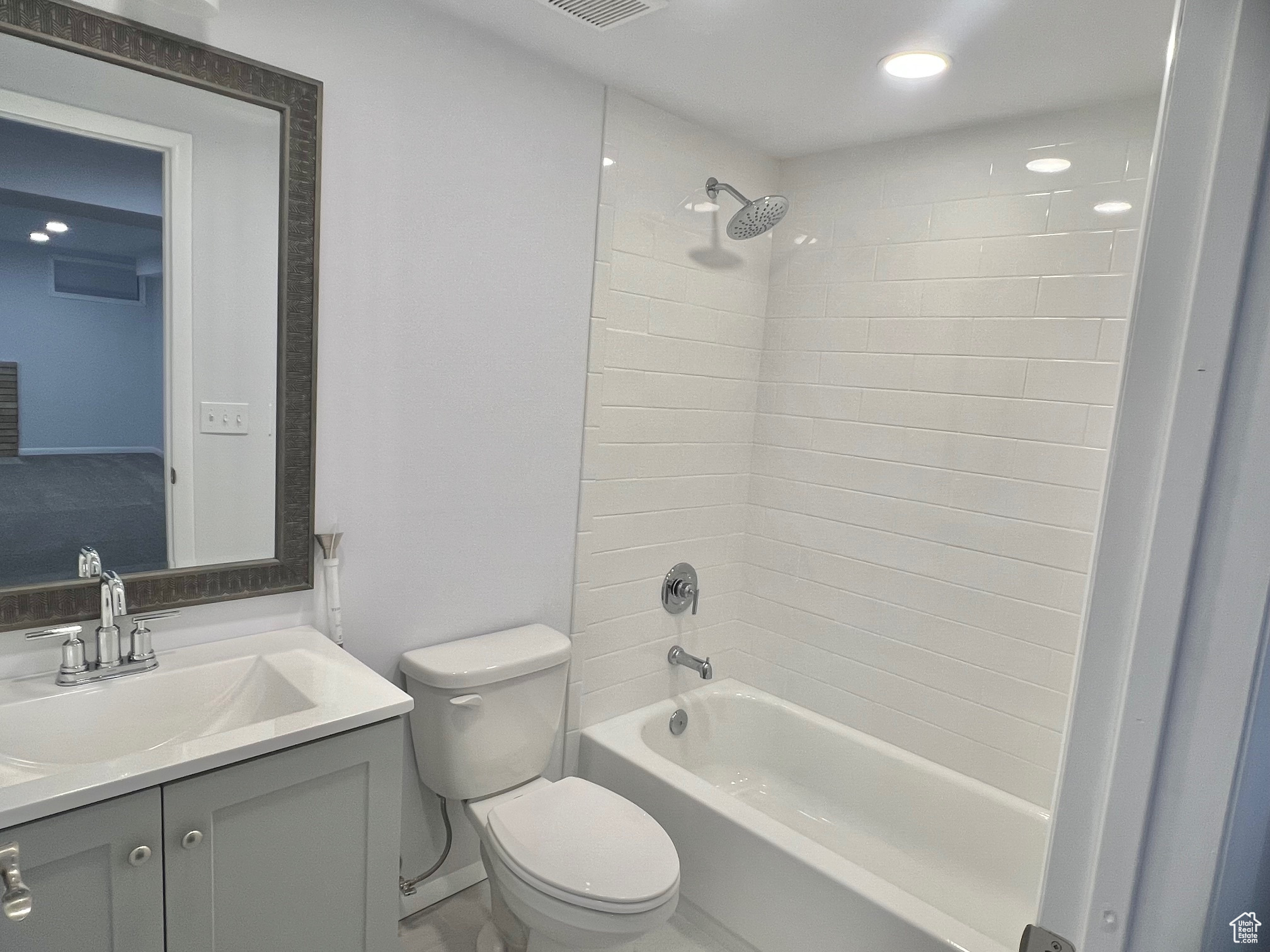 Full bathroom featuring vanity, toilet, and tiled shower / bath combo