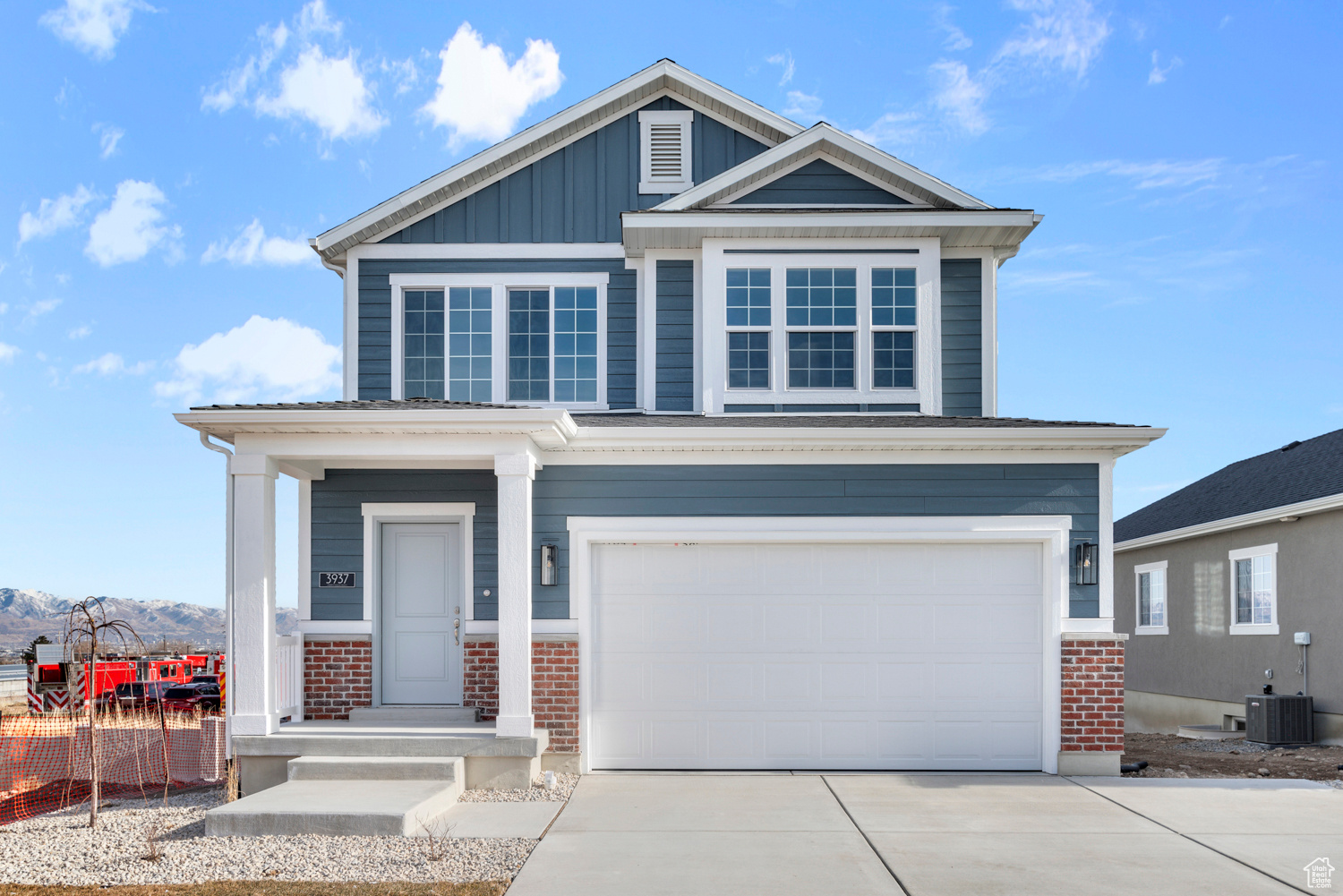 View of front of property featuring a mountain view, a garage, and cooling unit