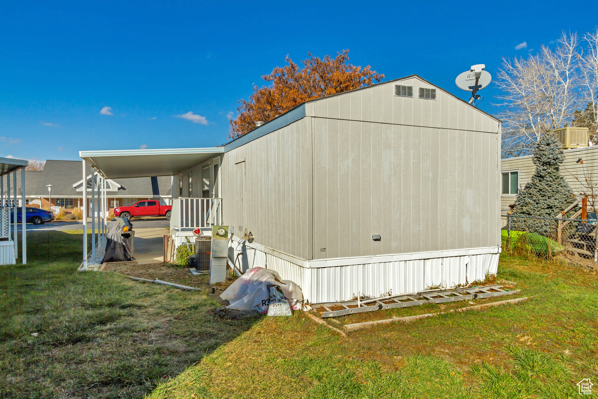 View of property exterior with a carport and a yard