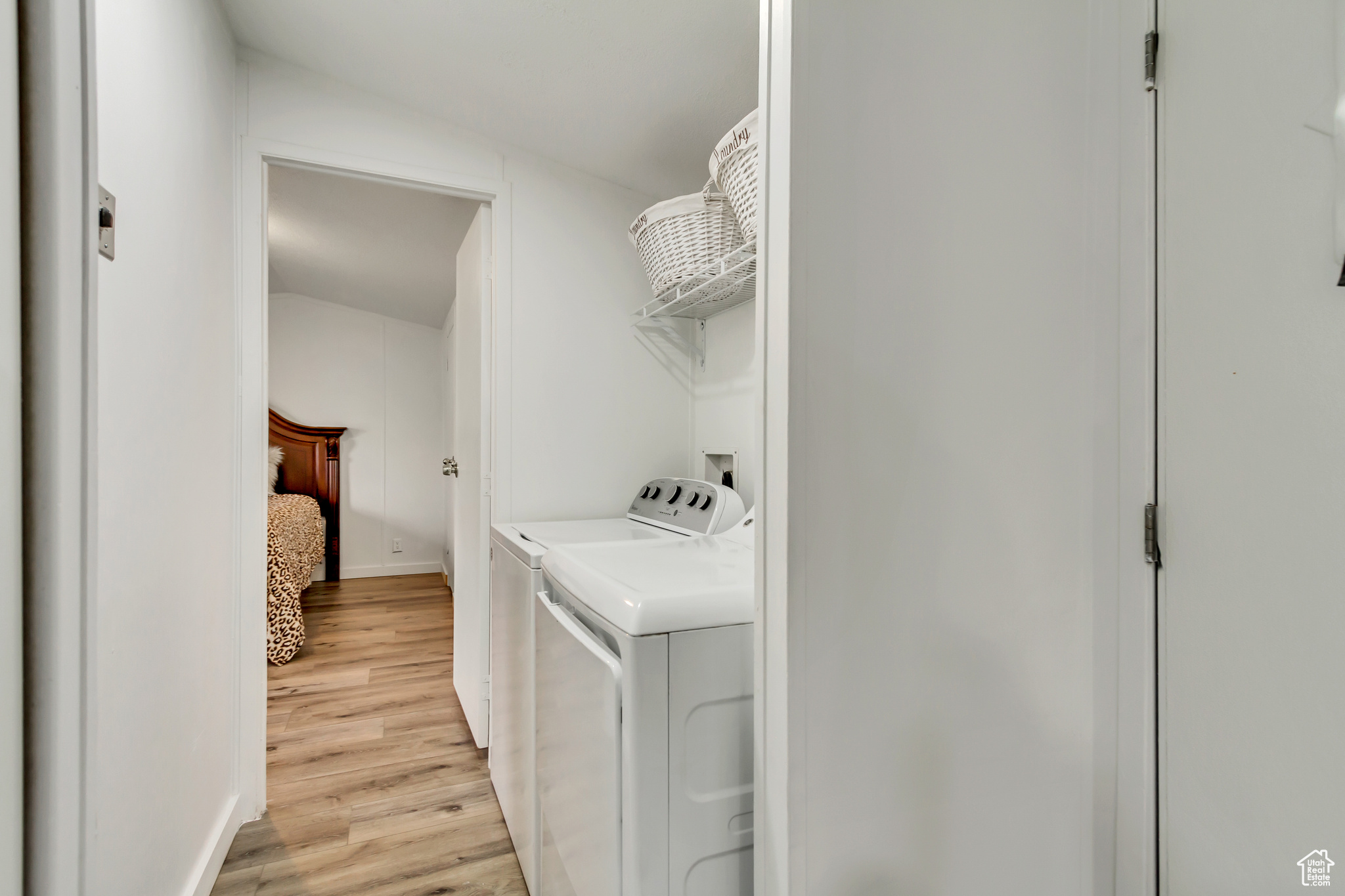 Washroom with washer and dryer and light hardwood / wood-style floors