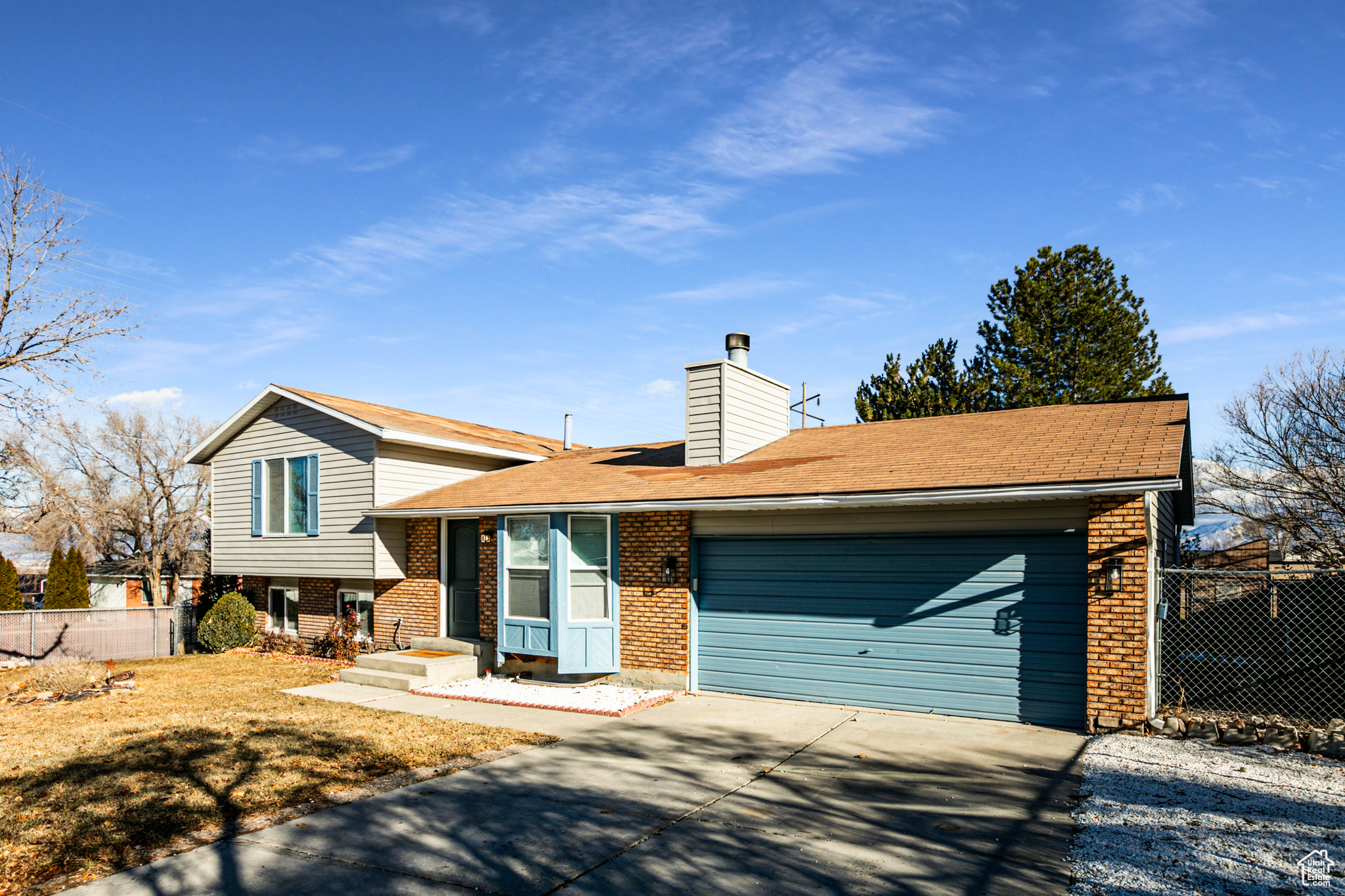 Split level home with a garage and a front yard