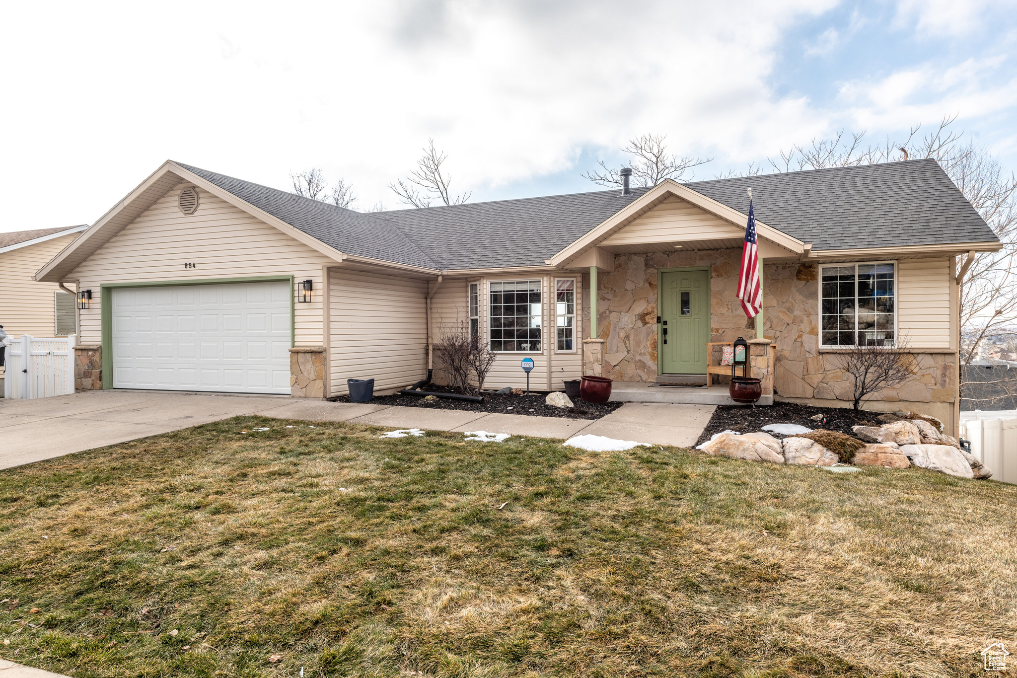 Ranch-style house featuring a front yard and a garage