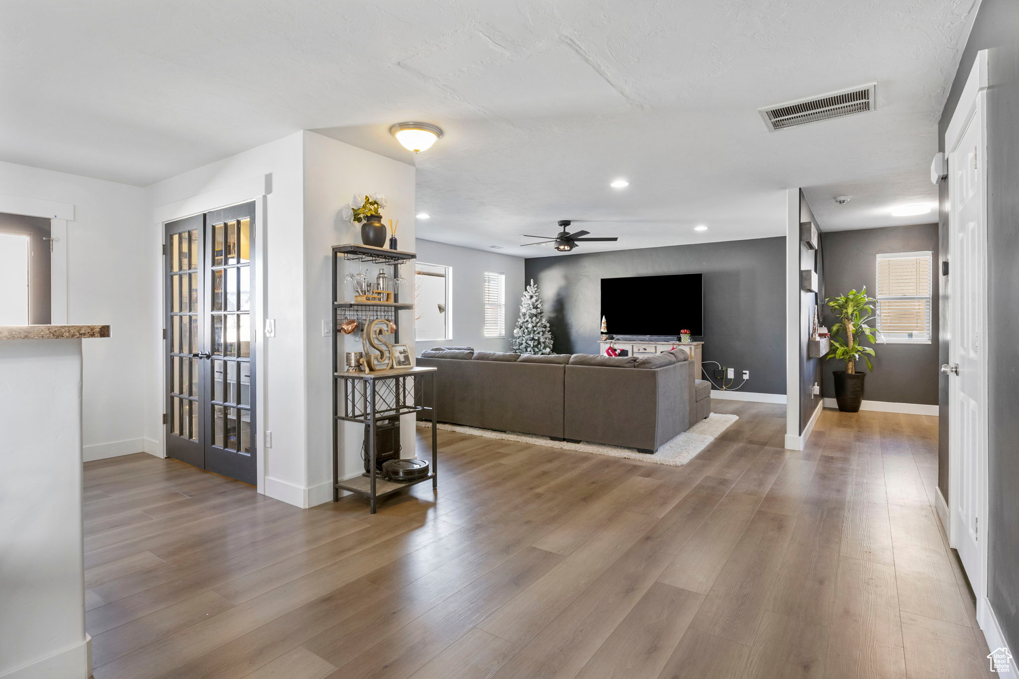 Living room featuring ceiling fan, hardwood / wood-style floors, a healthy amount of sunlight, and french doors