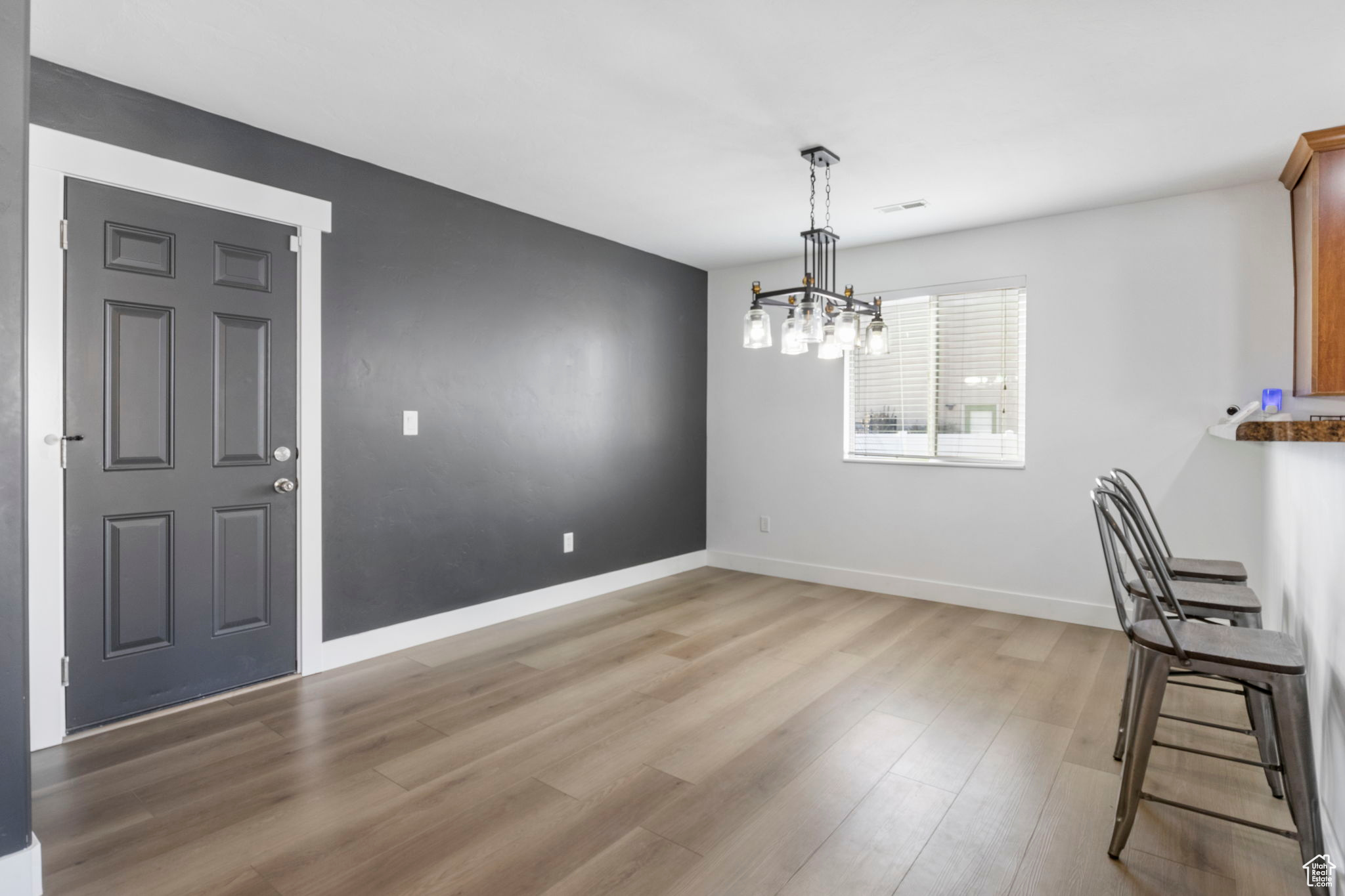 Unfurnished dining area featuring a chandelier and light wood-type flooring