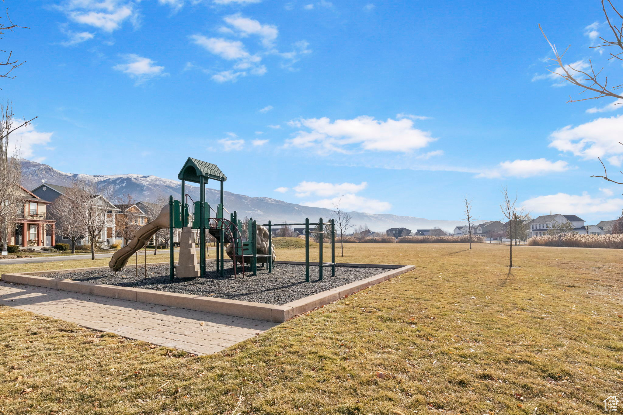 View of jungle gym with a mountain view and a yard