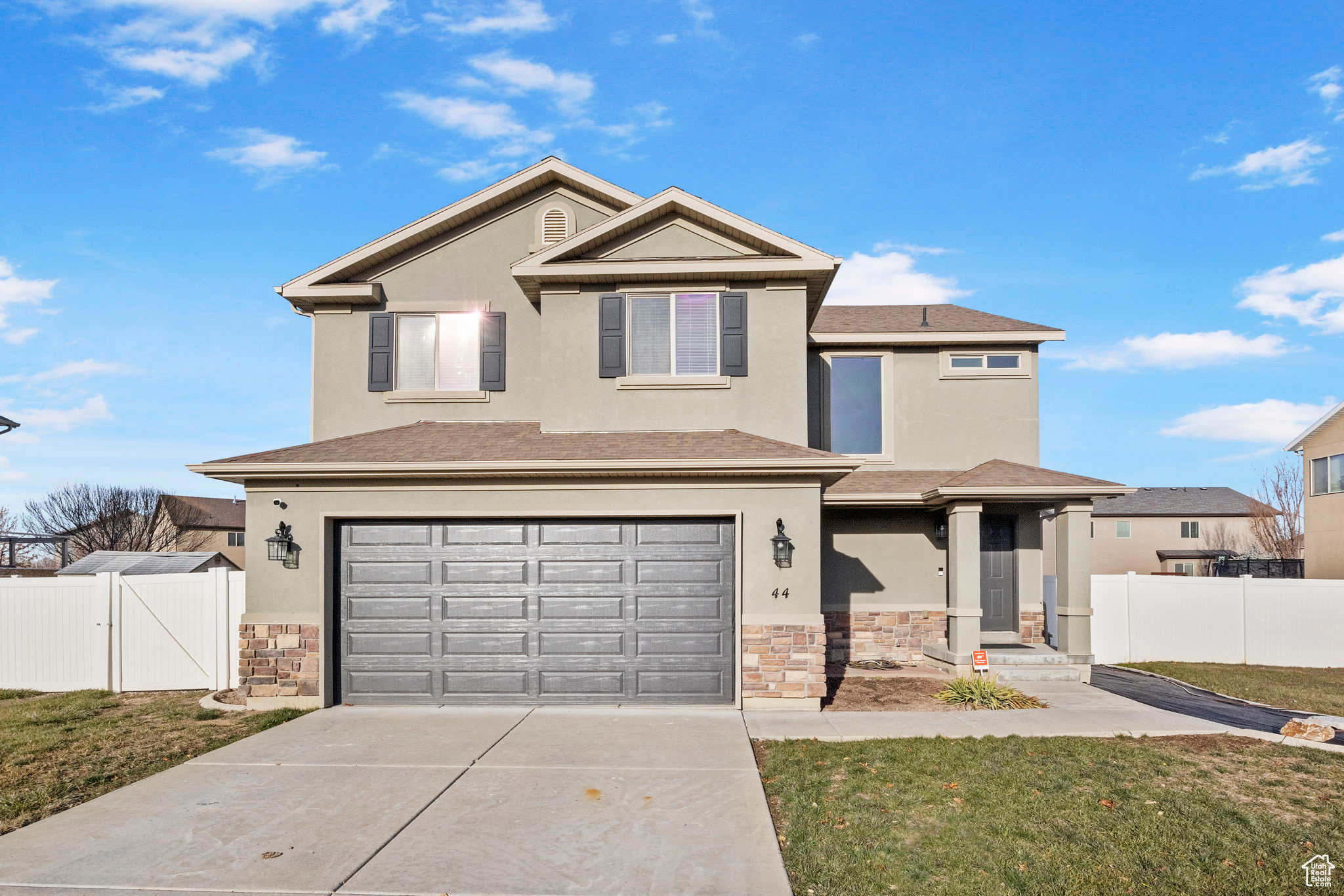 Front of property with a garage and a front lawn