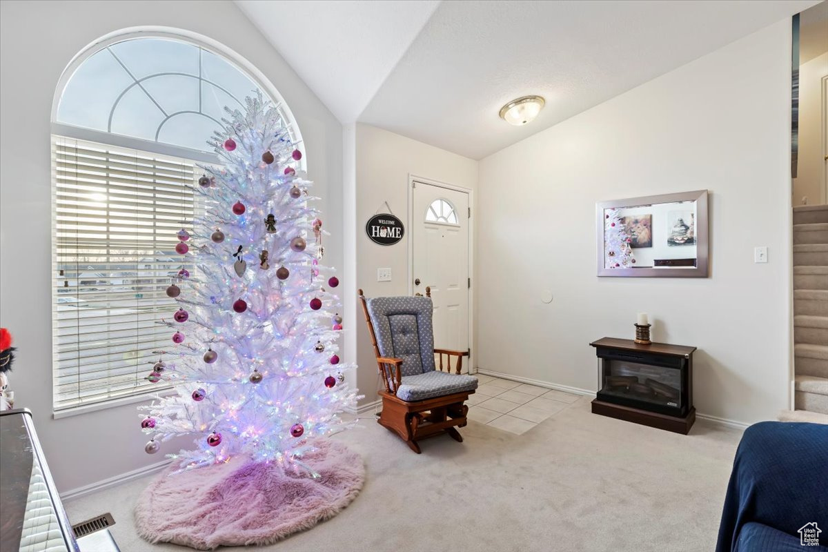 Interior space with lofted ceiling and light carpet