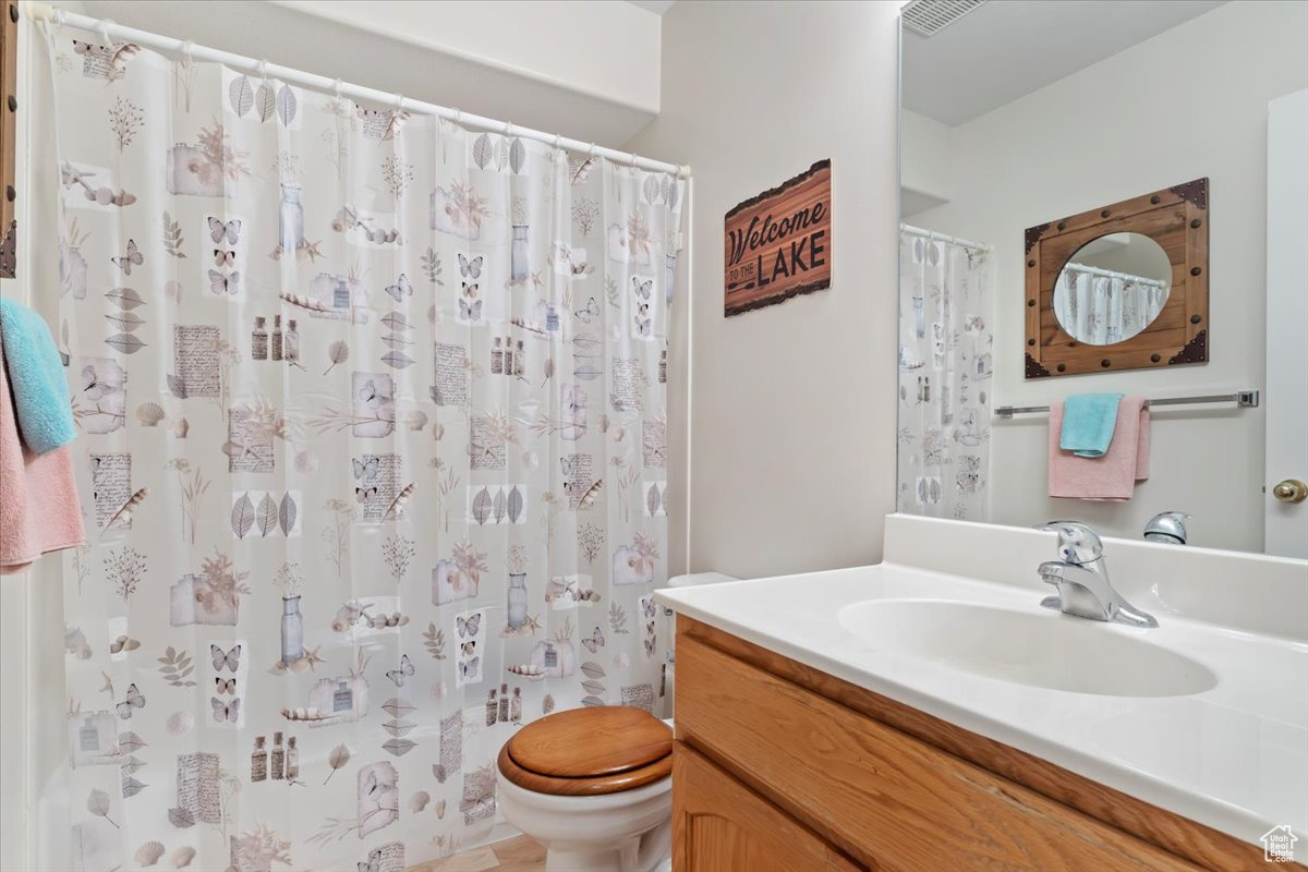 Bathroom with a shower with curtain, vanity, and toilet