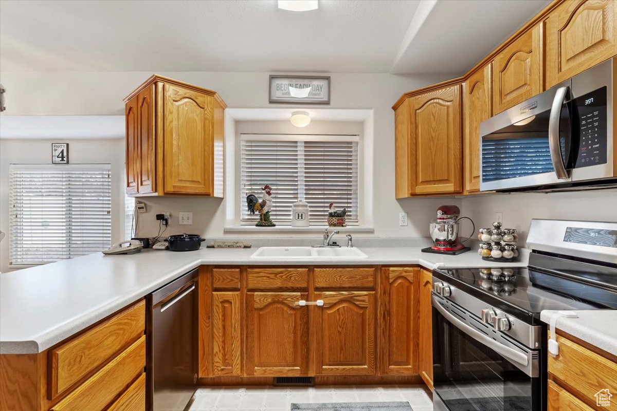 Kitchen with kitchen peninsula, sink, and stainless steel appliances