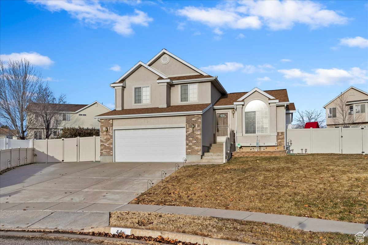 View of property with a garage and a front yard