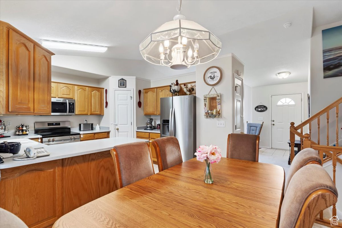 Tiled dining space with vaulted ceiling and a notable chandelier