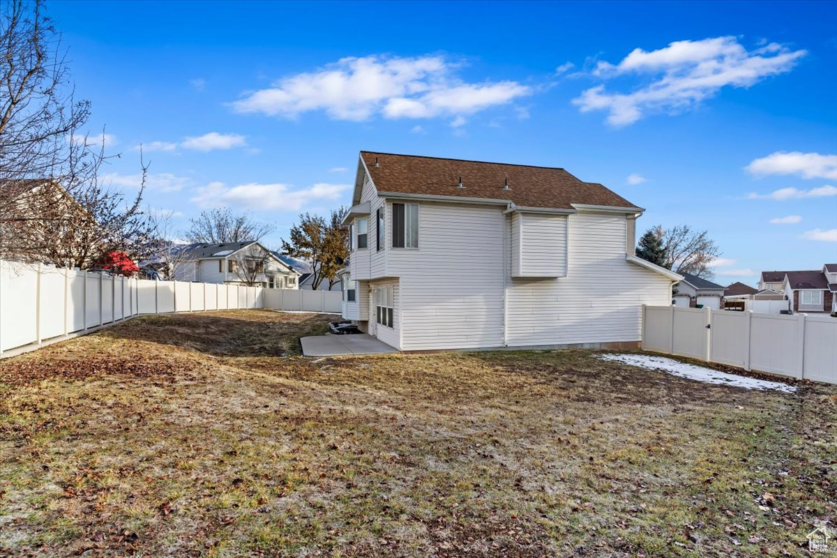 Back of property featuring a yard and a patio